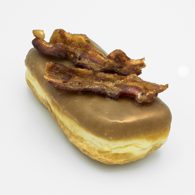 Rectrangular doughnut with maple frosting and two slices of bacon