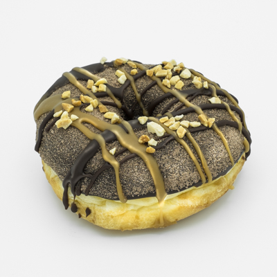 Ring doughnut with chocolate frosting, mocha powder, peanuts, drizzles of caramel and chocolate
