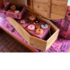 Voodoo Doughnut Coffin of Doughnuts open on a pink bench