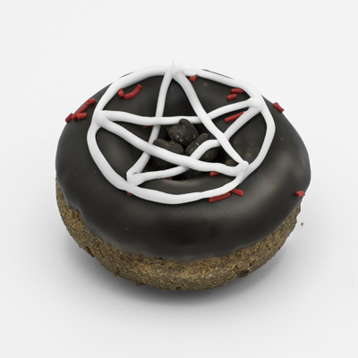 Chocolate cake doughnut with chocolate frosting a white frosting pentagram, a few red sprinkles