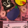 Doughnuts shaped and decorated as poop emoji, face blowing kiss emoji, and eggplant emoji