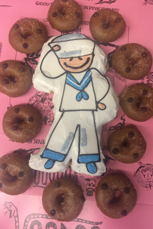 Doughnut shaped and frosted with a sailor stick figure saluting