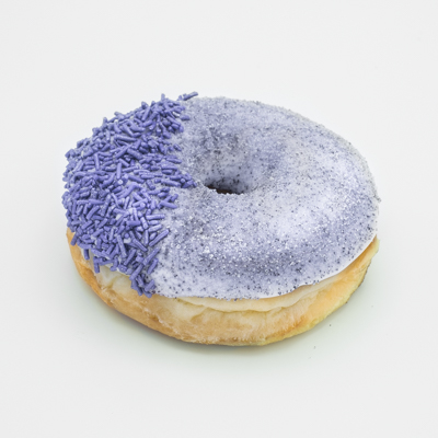 Raised yeast doughnut with vanilla frosting, coated with grape dust, lavender sprinkles on one side.