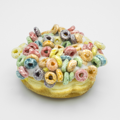 A raised yeast doughnut with vanilla frosting and Fruit Loops.