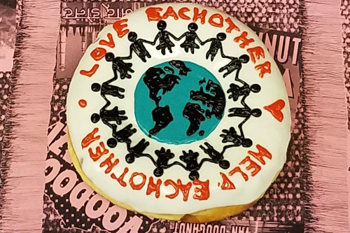 Love Each Other Doughnut with silhouettes holding hands around the earth