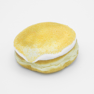 Round doughnut with mango jelly, vanilla frosting, sprinkled with orange Tang