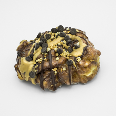 Fried dough doughnut, banana chunks, chocolate peanut butter drizzle, peanuts, chocolate chips.