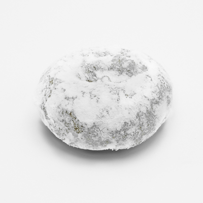 Cake doughnut covered all over with white powdered sugar.