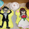 Two doughnuts shaped and frosted to look like a bride and groom