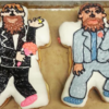 Two doughnuts shaped and frosted to look like two men in suits