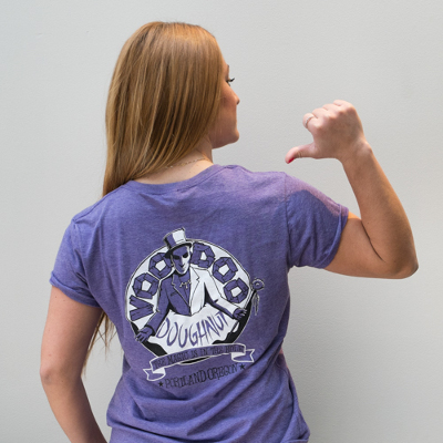 Woman in purple heathered t-shirt with Voodoo logo on back.