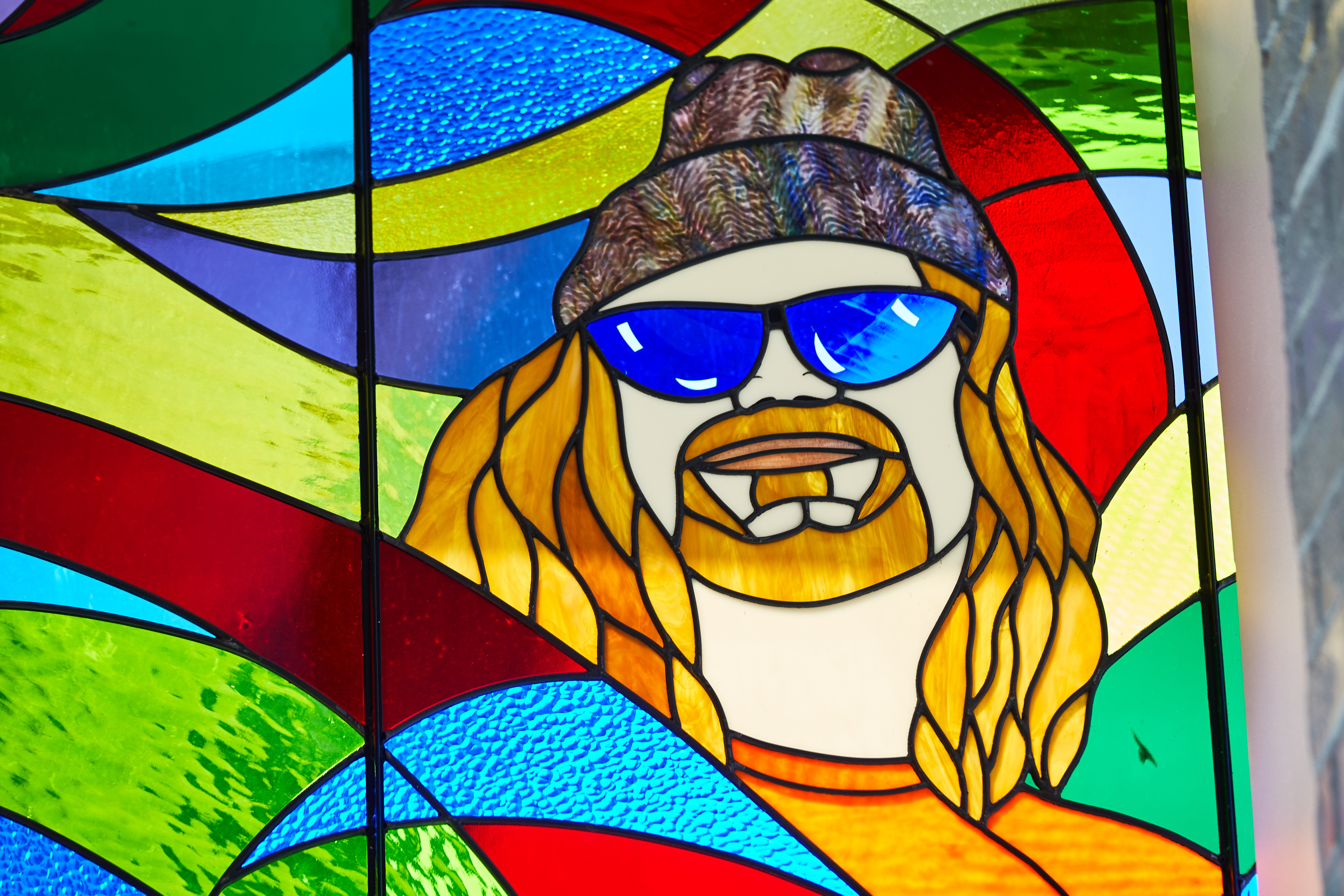 Stained Glass window of Tres Shannon's face with swirly colored background