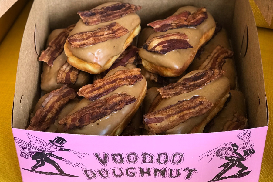 Pink Voodoo Doughnut Box showing a dozen Bacon Maple Bars