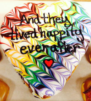 Heart Shaped Doughnut with multi-colored icing and the words "And they lived happily ever after"