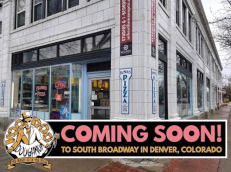 Street corner at South Broadway with banner: Coming Soon Voodoo Doughnut logo