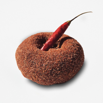 Chocolate cake doughnut dusted with cinnamon, cayenne pepper, and topped with a dried red chili pepper..