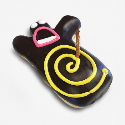 Rectangle shaped doughnut frosted with chocolate, a face, a yellow spiral, and a pretzel.