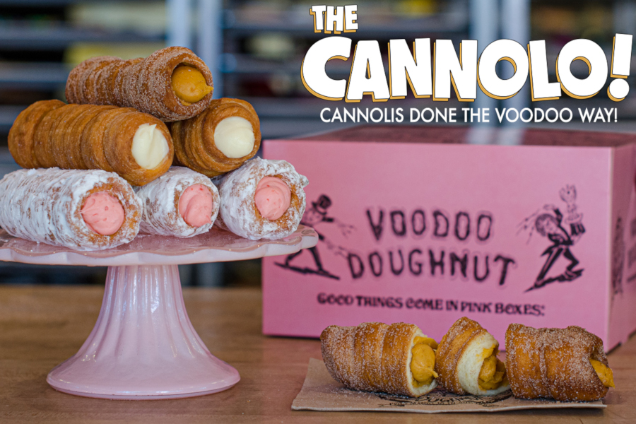 Pink stand with 6 cannolo doughnuts, pink voodoo box, and doughnut racks in the background