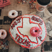 Doughnut with white frosting and pink letters Are you Ready Texas