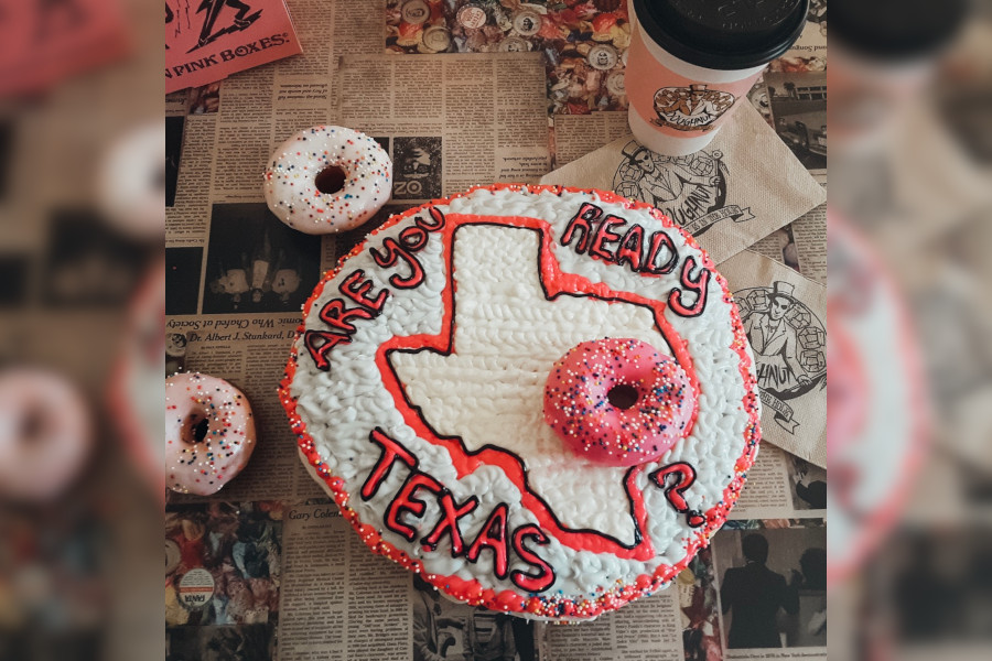 Doughnut with white frosting and pink letters Are you Ready Texas