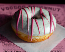 Ring doughnut with grey icing and pink drizzle with side lighting