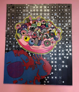 A large doughnut with smaller colorful doughnuts atop is depcited in duct tape