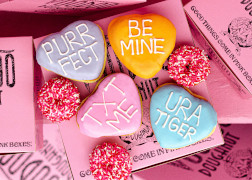 Four heart shaped doughnuts with messages "purr fect" "Be Mine" "UR A Tiger" and "TXT Me"