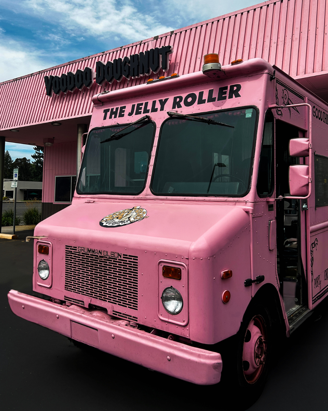 voodoo doughnut pink food truck van in front of a pink voodoo doughnut shop
