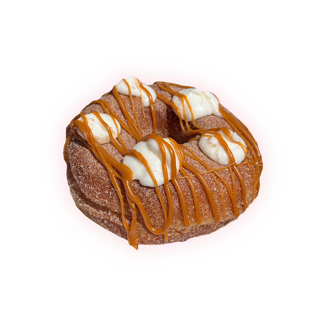 shows churro cheesecake doughnut Coated in cinnamon sugar, topped with creamy cheesecake swirls, and drizzled with decadent caramel.