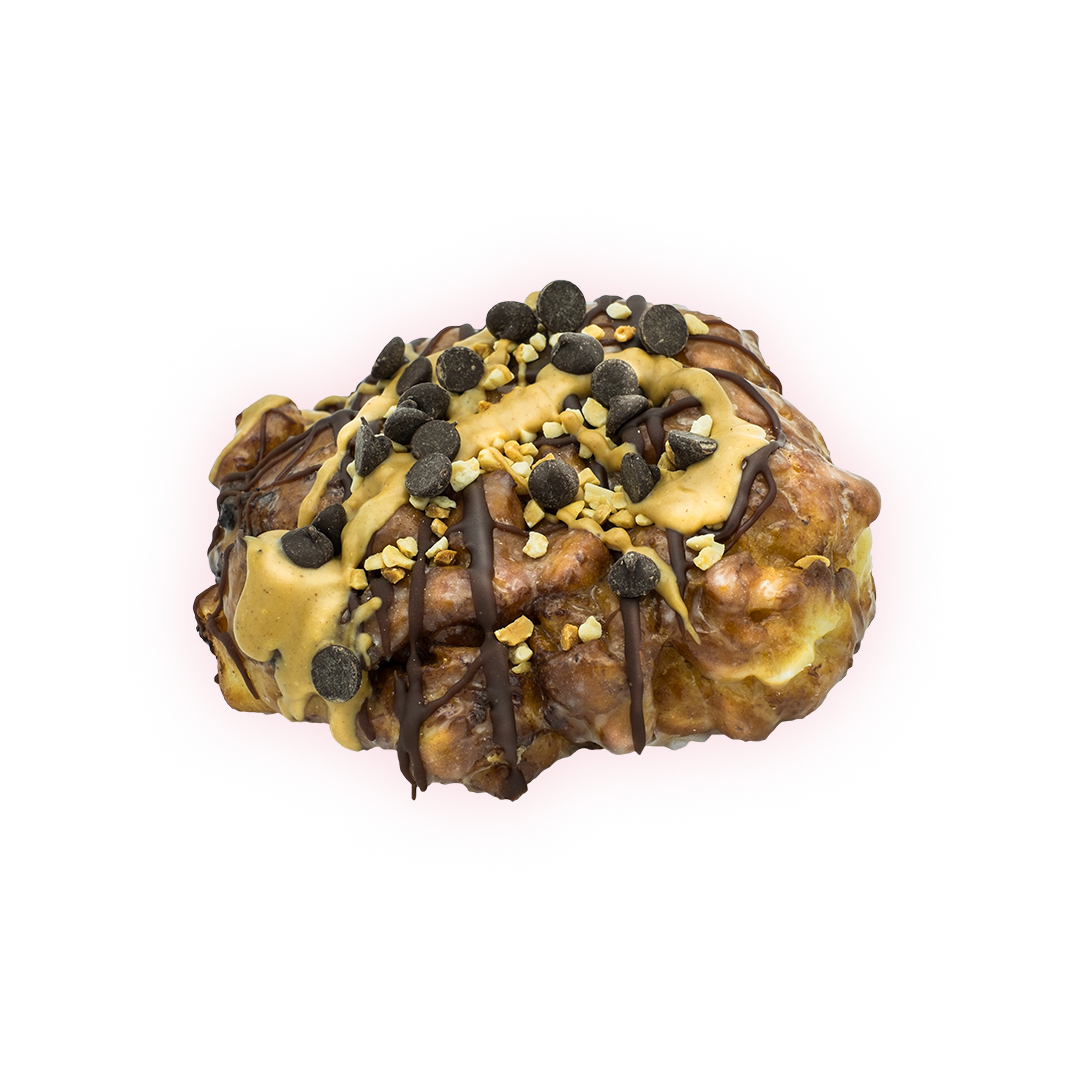 Fried dough with banana chunks and cinnamon, topped with glaze, chocolate chips, peanuts, and chocolate and peanut butter drizzle.